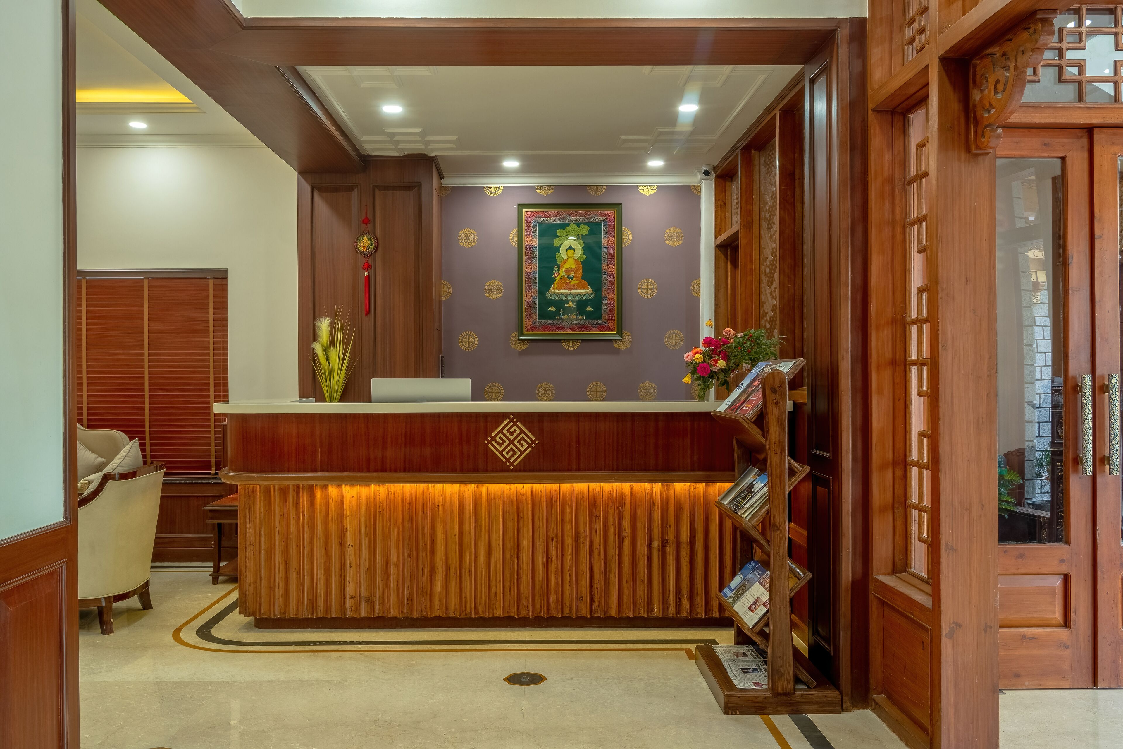 A reception desk with a wooden finish, a framed picture above it, and a bookshelf to the right.