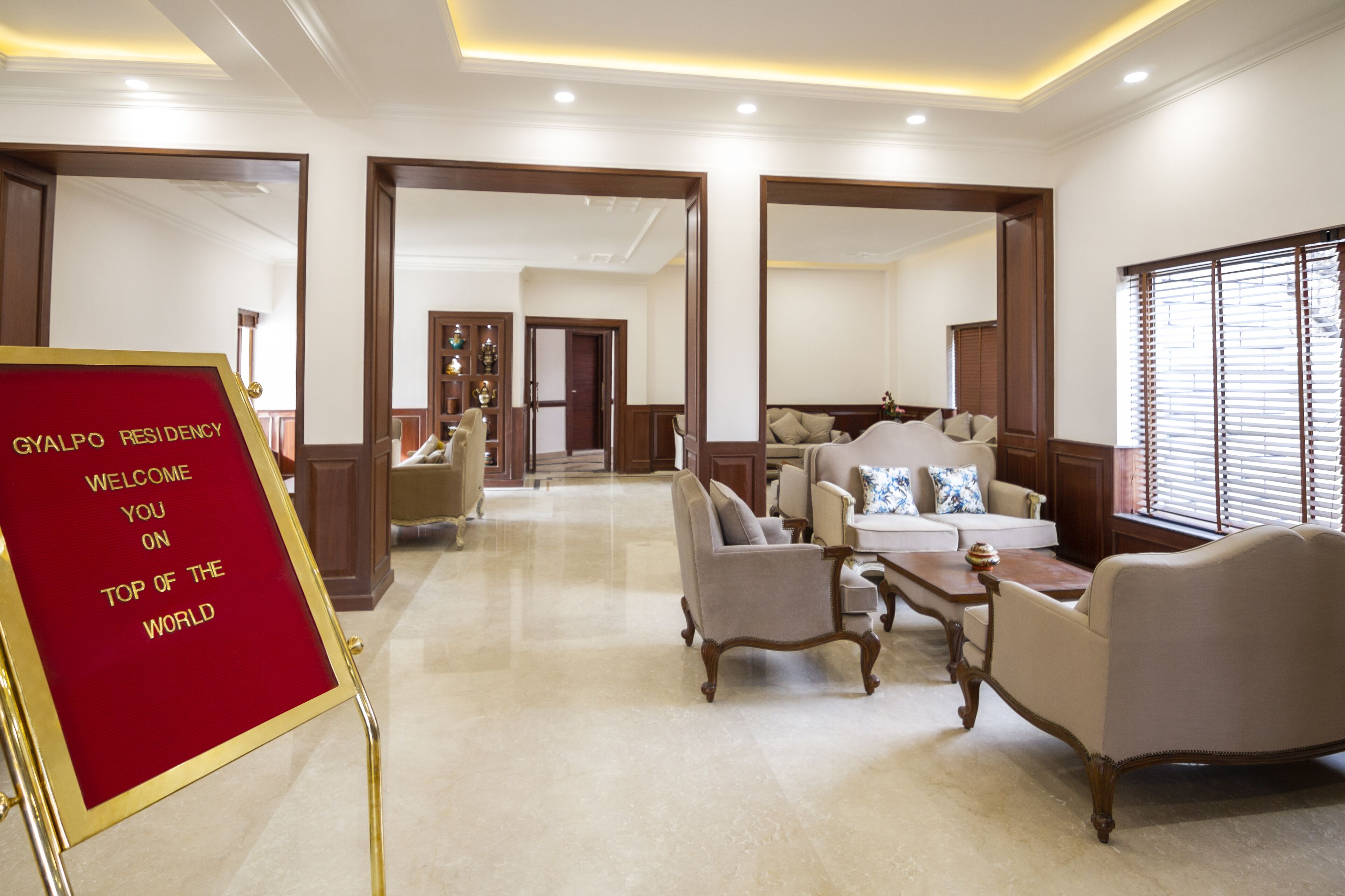 A spacious lobby with a red welcome sign, a sofa set, and a coffee table.