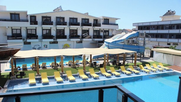 Ein Pool auf dem Dach mit Liegestühlen und einer überdachten Liegefläche, umgeben von Gebäuden.