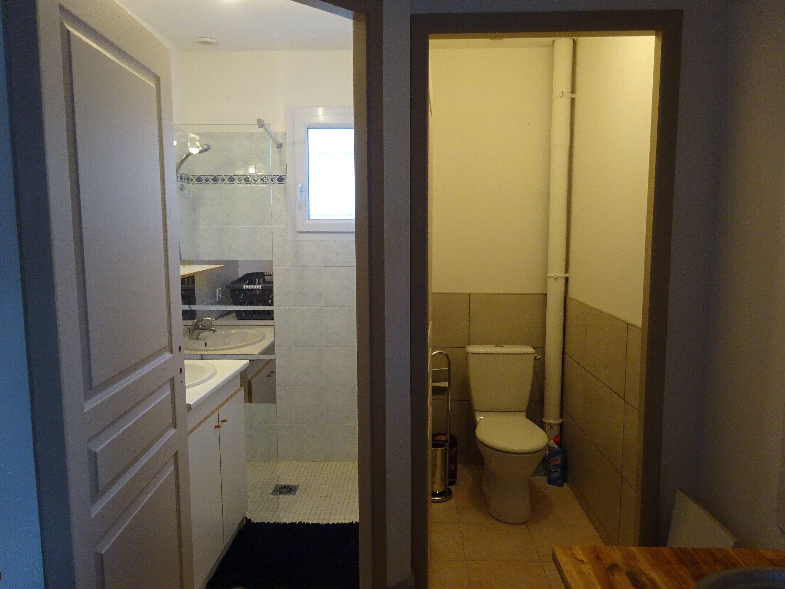 A bathroom with a toilet, sink, and shower area.