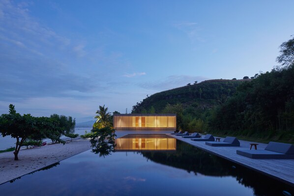 Una piscina al aire libre, sillones reclinables de piscina