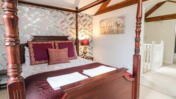 Un lit à baldaquin avec une tête de lit et un pied de lit en bois, une tête de lit en marbre et un motif de papier peint floral.