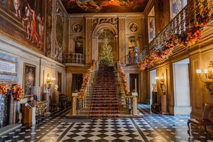 A grand staircase with ornate decorations, a checkered floor, and classical architectural elements.