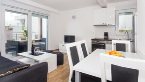 A modern apartment with a dining area, kitchen, and balcony. - 2 bedroom stunning apartment in Makarska (Makarska)