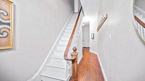 A staircase with wooden handrails and white walls, leading to a door at the top. - Scenic South Main Apartment with Breathtaking Views for 3 Guests (Saint Charles)