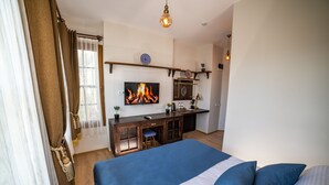 Ein Schlafzimmer mit Bett, Schreibtisch und Fernseher, der ein Feuer zeigt.