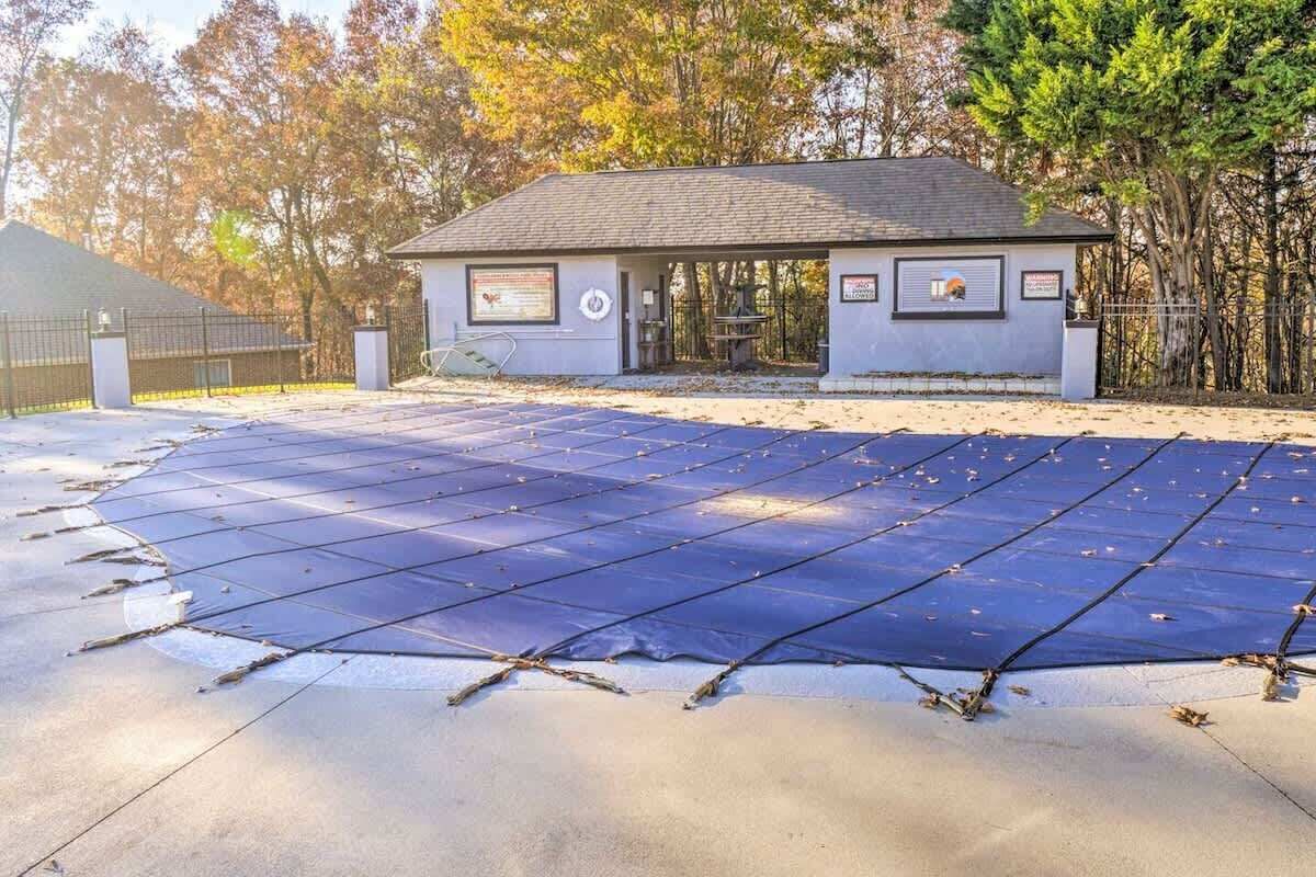 Ein kleines Gebäude mit überdachter Terrasse und einer großen Solarpanel-Anlage auf dem Gelände.