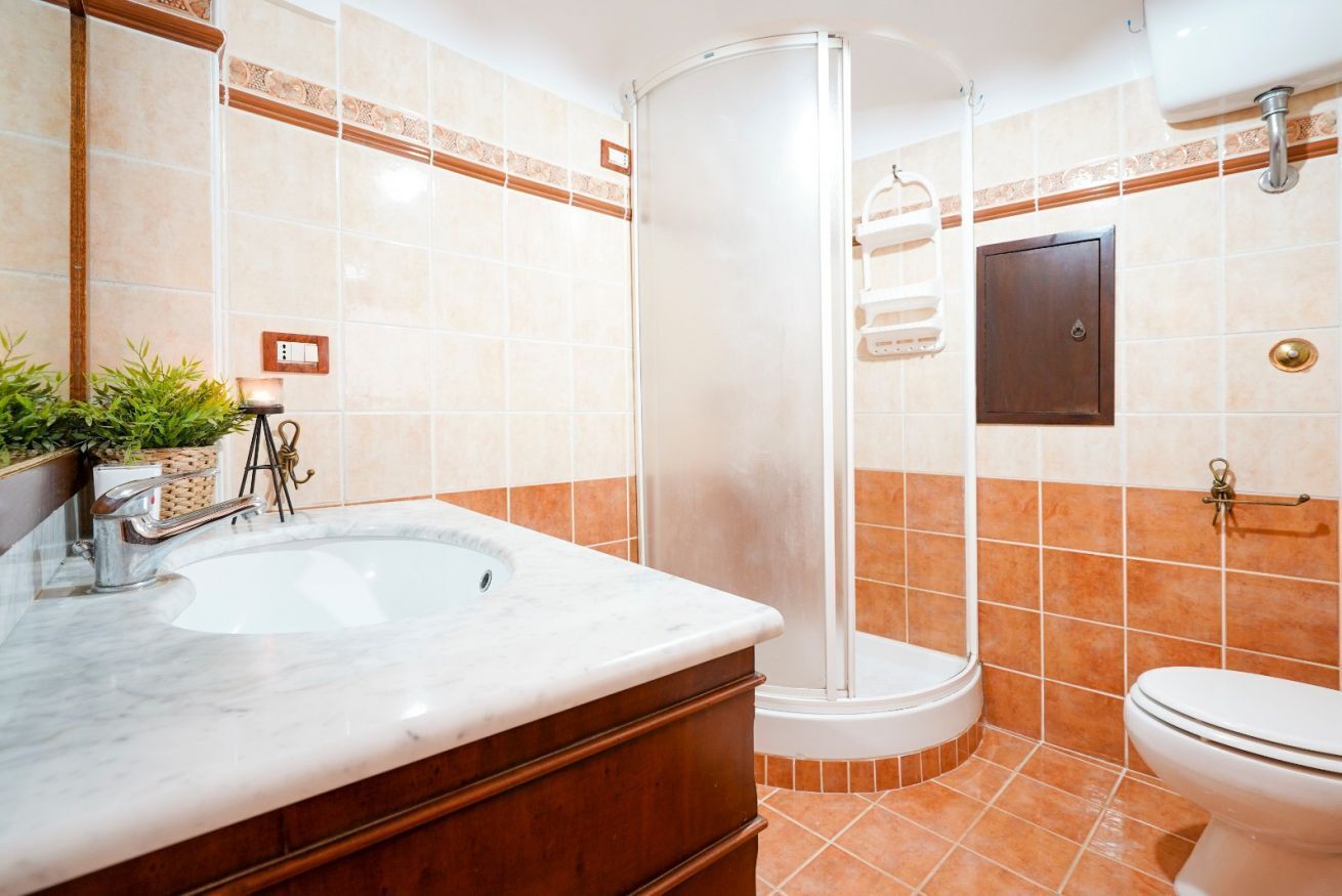 A bathroom with a sink, a shower, and a toilet.