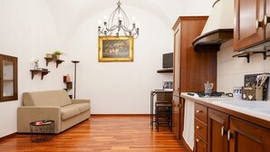 Eine moderne Küche mit Holzausstattung, einem Essbereich inklusive Sofa und einer Kronleuchter.