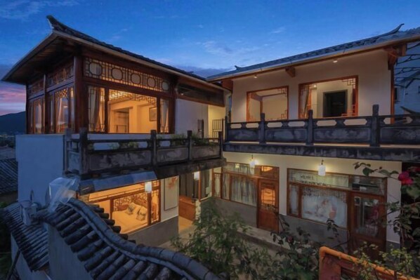 A traditional building with a wooden balcony and multiple windows.