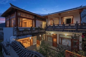 A traditional building with a wooden balcony and multiple windows. - Snail Inn (Tengchong) (Tengchong)