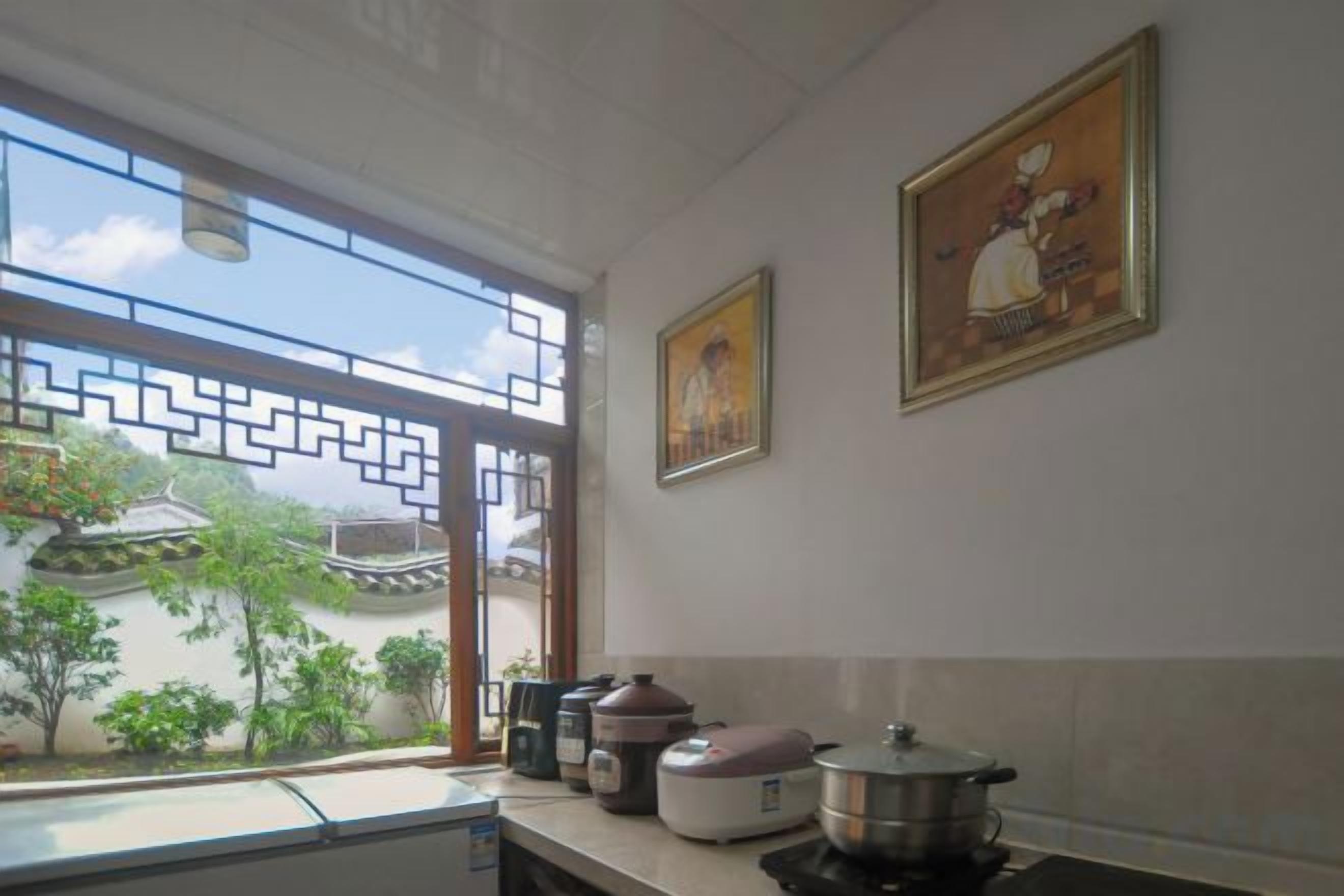 Una cocina con ventana, estufa y dos cuadros en la pared.
