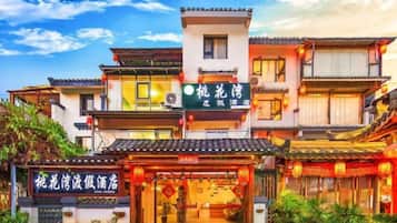 A traditional building with multiple levels, a signboard, and a well-maintained entrance.