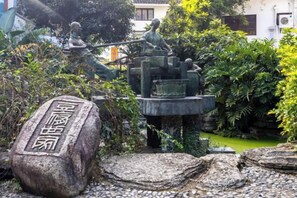 A traditional Chinese garden with stone statues, a stone tablet, and a water feature. - Peach Blossom Bay Resort (Guilin Ludiyan Scenic Area) (Guilin)
