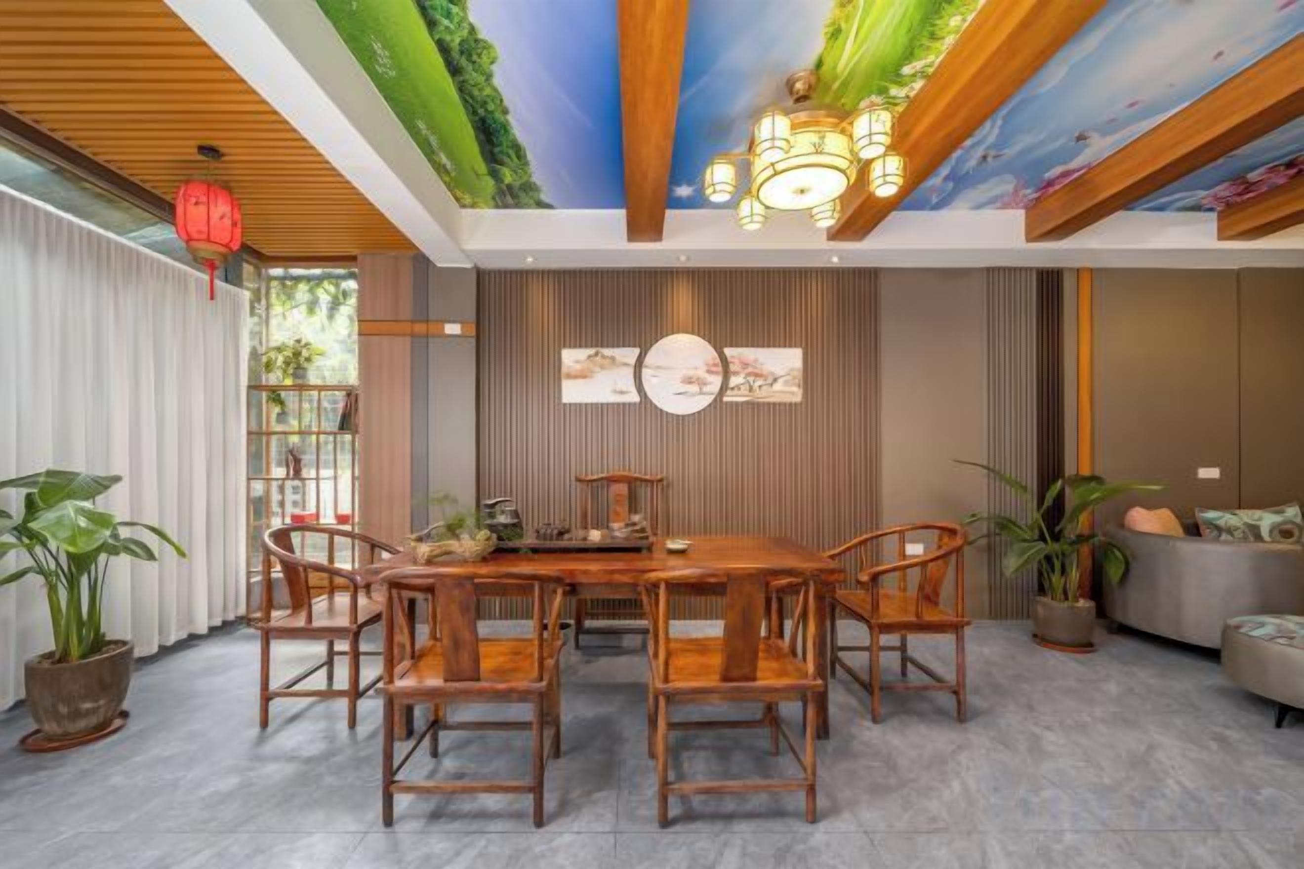 A dining area with a wooden table and chairs, a ceiling mural, and a sofa in the background.