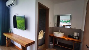 Une salle de bain moderne avec un banc en bois, un lavabo et un miroir.