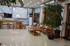 A spacious room with a large screen, wooden furniture, and a potted plant. - Shanxian Matou Inn (Hangzhou)