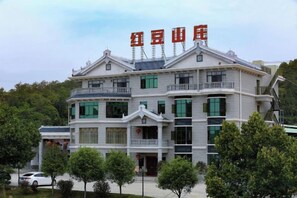 A multi-story building with a traditional architectural style, featuring balconies and a prominent entrance. - Hongdou Mountain Villa (Pingyuan)