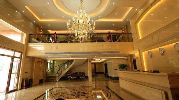 A spacious lobby with a grand chandelier, a reception desk, and a staircase leading to an upper level. - Hongdou Mountain Villa (Pingyuan)