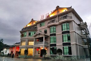 A multi-story building with balconies and large windows, likely a hotel or residential building. - Hongdou Mountain Villa (Pingyuan)