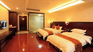 A hotel room with two beds, a wooden floor, a desk with a chair, a TV, and a door leading to a bathroom. - Hongdou Mountain Villa (Pingyuan)