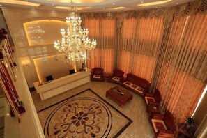 A grand lobby with a chandelier, seating area, and a reception desk. - Hongdou Mountain Villa (Pingyuan)