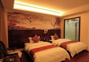 A hotel room with two beds, a nightstand, a chair, and a wall with a painting. - Hongdou Mountain Villa (Pingyuan)