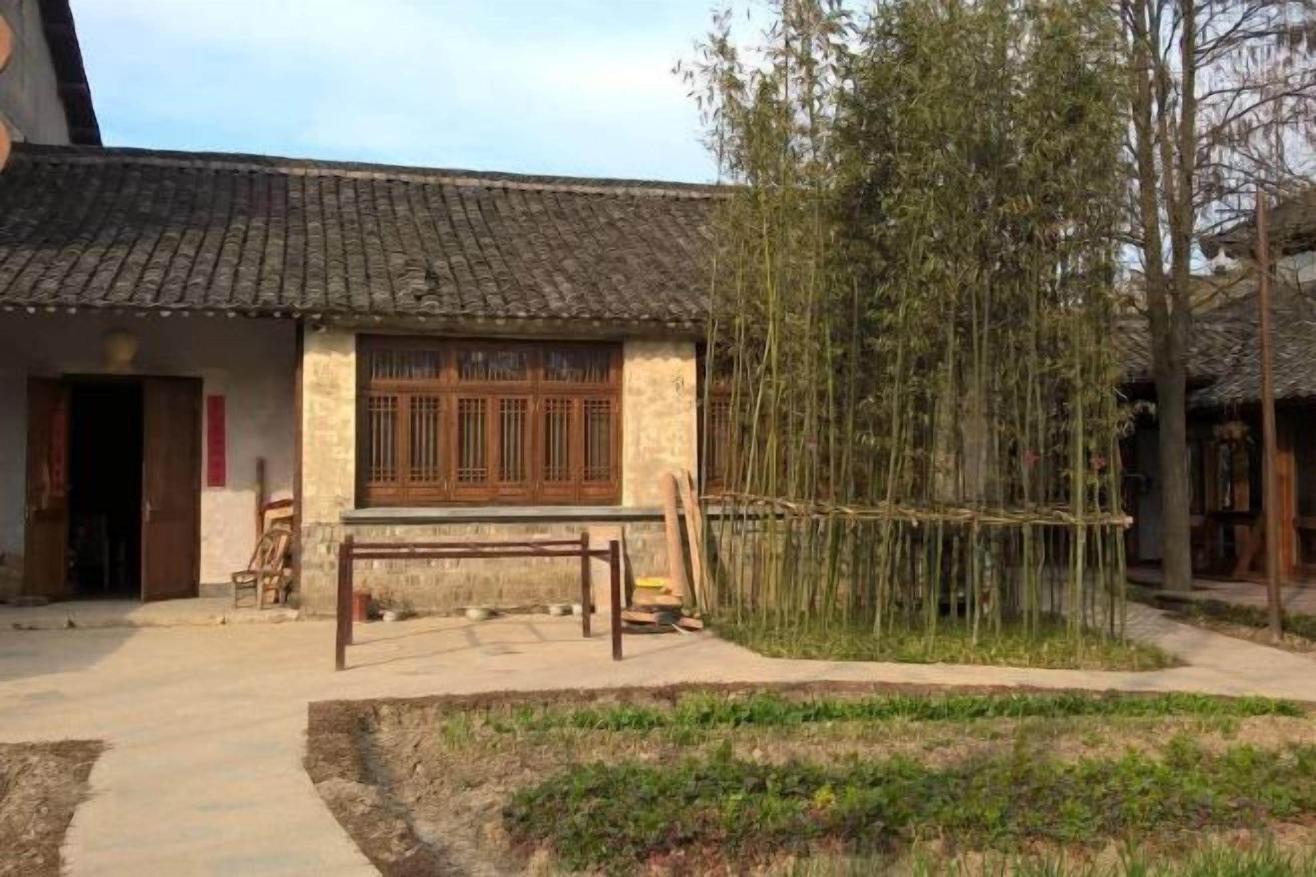 A traditional building with a tiled roof, a wooden door, and a window with wooden lattice.