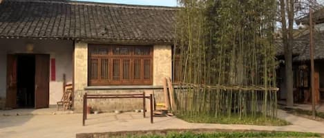 A traditional building with a tiled roof, a wooden door, and a window with wooden lattice.