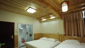 A room with two beds, wooden ceiling, and a glass door leading to a bathroom. - Xingfu Yayuan Guesthouse (Tongxiang)