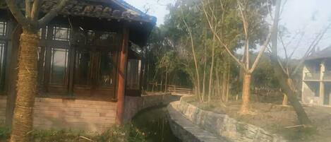 A traditional building with a brick facade, a wooden porch, and a stone pathway.