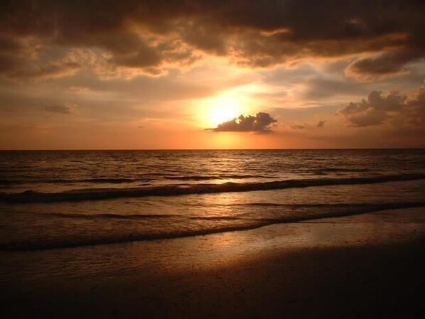 A sunset over the ocean with waves on the shore. - Waterfront 2BR, 2BA condo with heated pool, WiFi, and marina access. (Marco Island)