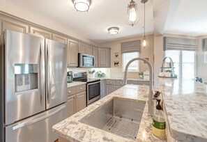 Lavavajillas, cafetera/tetera, utensilios de cocina, mesa de comedor