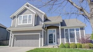 A two-story house with a garage, a front door, and a small front yard with bushes. - Gardner 5 bedroom 3 bath home. Family friendly and long stay  (Gardner)