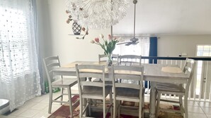 A dining area with a wooden table, white chairs, a patterned rug, and a decorative ceiling light. - Gardner 5 bedroom 3 bath home. Family friendly and long stay  (Gardner)