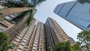 A high-rise building with a modern architectural design, surrounded by greenery. - Grace Apartment (Shenzhen)