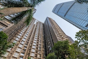 A high-rise building with a modern architectural design, surrounded by greenery. - Grace Apartment (Shenzhen)