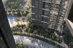 A high-rise building with multiple balconies, surrounded by greenery and a curved road. - Grace Apartment (Shenzhen)