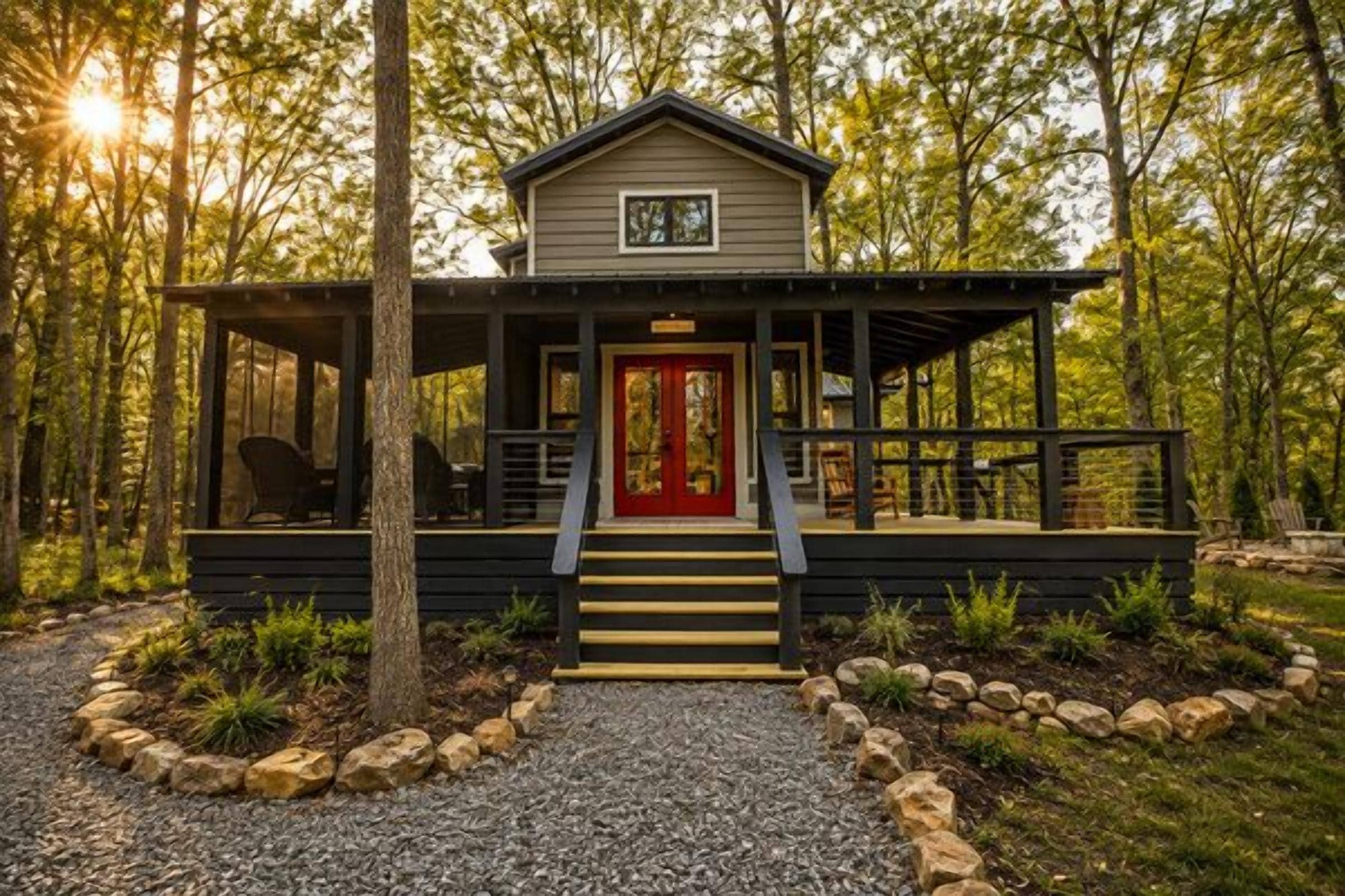 A cabin with a red door, a porch, and a gravel path leading to it.