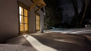 Un camino cubierto de nieve que lleva a un edificio con ventanas grandes.