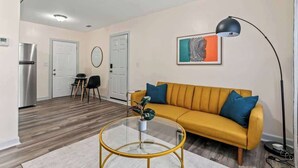 Ein Wohnzimmer mit einer Couch, einem Couchtisch und einem Kunstwerk an der Wand.