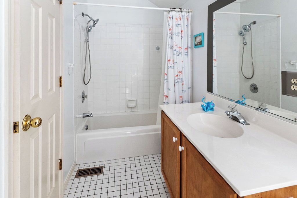A bathroom with a bathtub, a shower, a sink, and a mirror.
