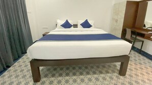 Una habitación de hotel con cama, escritorio y armario.