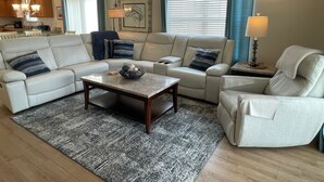 Un salon comprenant un canapé, des fauteuils, une table basse et un tapis.