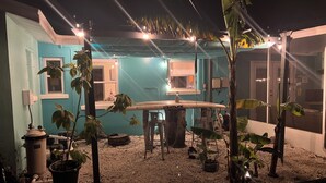 Un espace extérieur aménagé avec une table, des chaises et des plantes en pot.