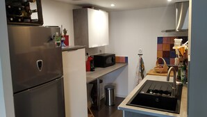 Une cuisine moderne équipée d’un réfrigérateur en acier inoxydable, d’un four à micro-ondes et d’une cuisinière à gaz.