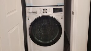 A stacked washer and dryer unit in a narrow hallway.