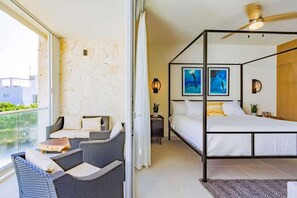 Uma varanda com mobiliário de vime, uma cama de dossel e obras de arte nas paredes.