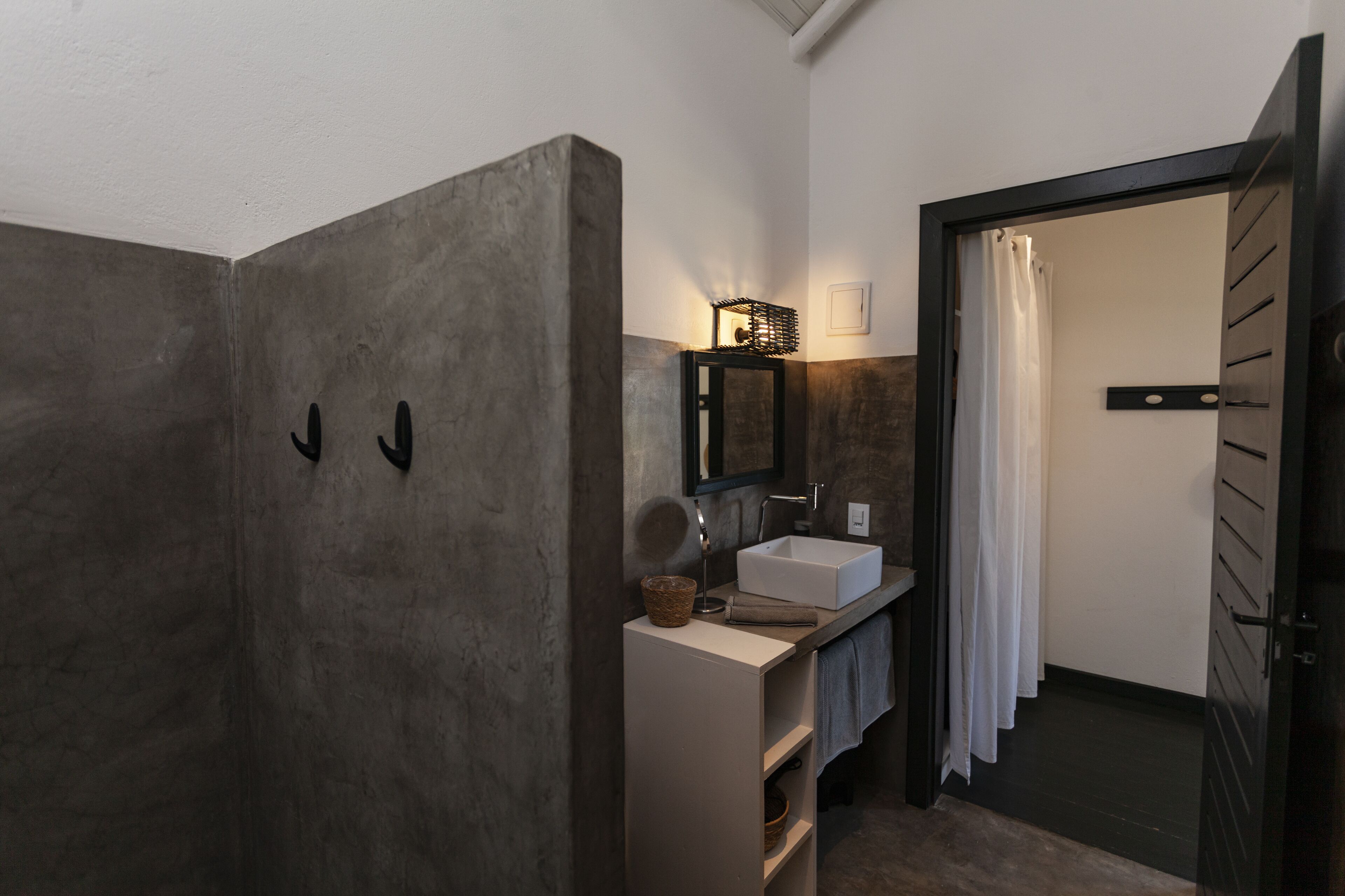 A bathroom with a large mirror, a sink, and a shower area.