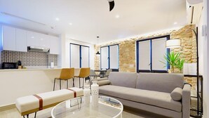 A modern living room with a sofa, two chairs, a glass coffee table, and a bench. - w* | Gorgeous 1BR in Casco Antiguo w/ Rooftop (Panamá)